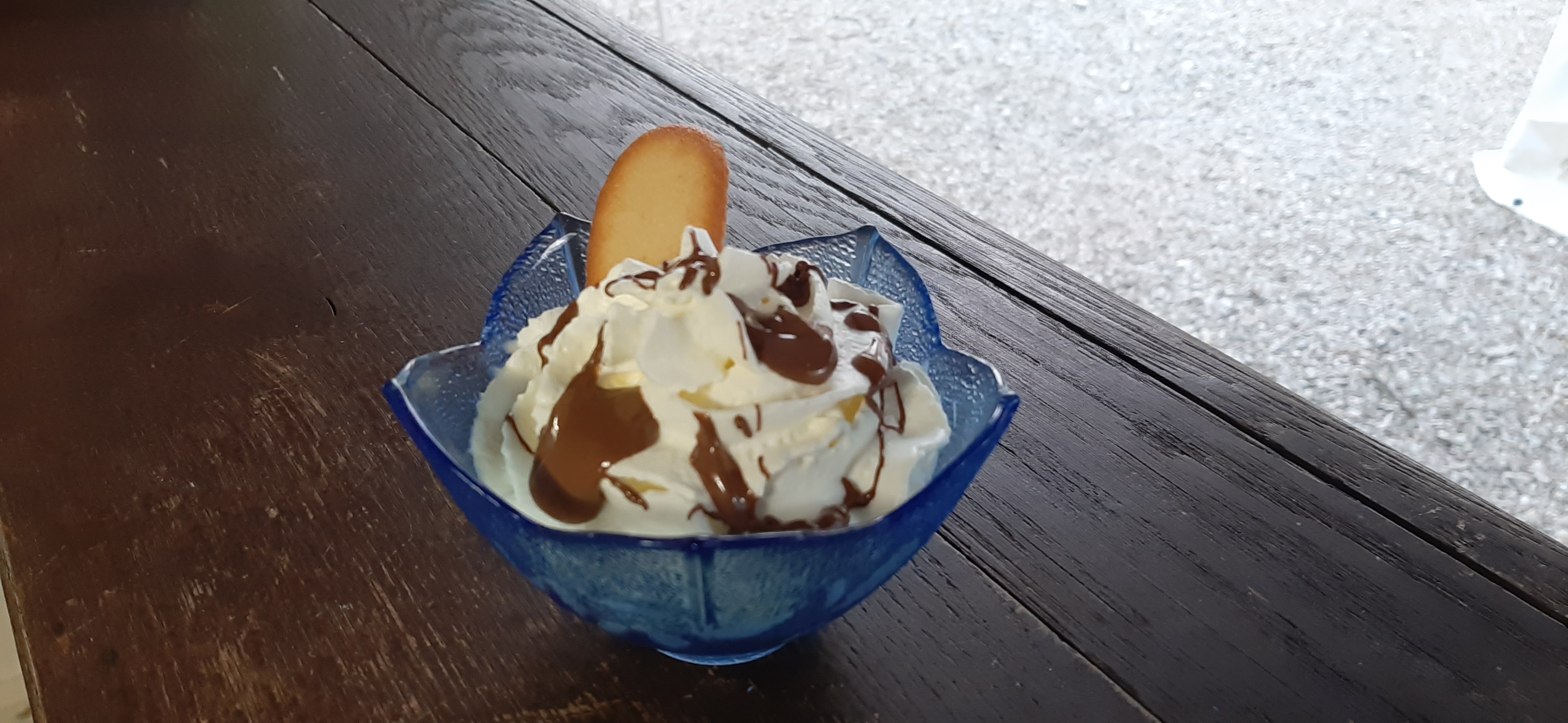 Photo d'une coupe contenant une boule de glace avec de la chantilly et du nappage au chocolat